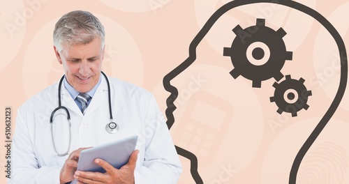 Composite of caucasian senior doctor using digital pc and human head with gears on peach background