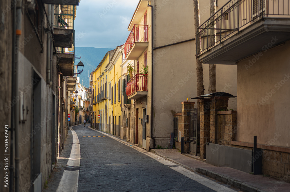 Obraz premium Narrow historic (medieval) streets of a small town in southern Italy. Old stone houses, wooden windows and doors, cobblestone road.
