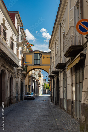 Fototapeta Naklejka Na Ścianę i Meble -  Narrow historic (medieval) streets of a small town in southern Italy. Old stone houses, wooden windows and doors, cobblestone road.
