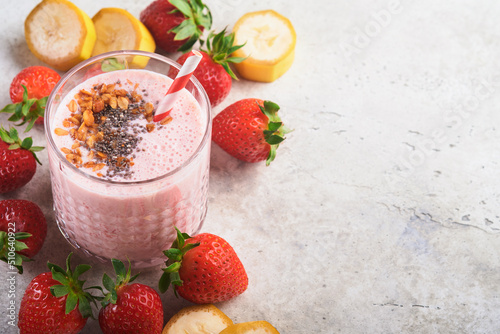 Strawberry smoothie. Vegan smoothie or milkshake from strawberry, banana and mint on white wooden table background. Clean eating, alkaline diet. Top view. Mock up.