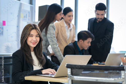 Asian businessman looking at the camera Working and meeting at the office at the company with colleagues at the back