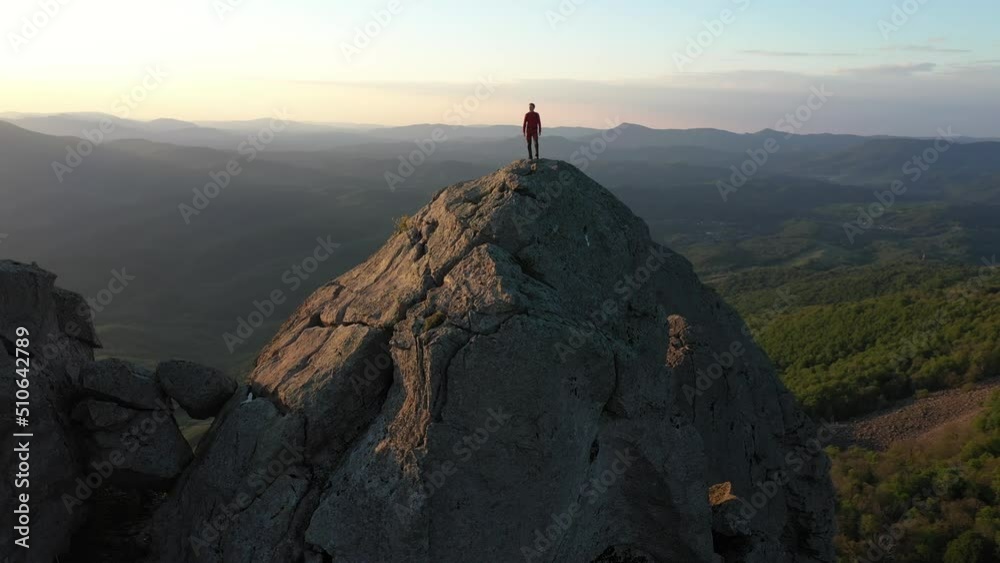 Traveler Reaching Top of Mountain and Hands Raising in a Sunset Light.