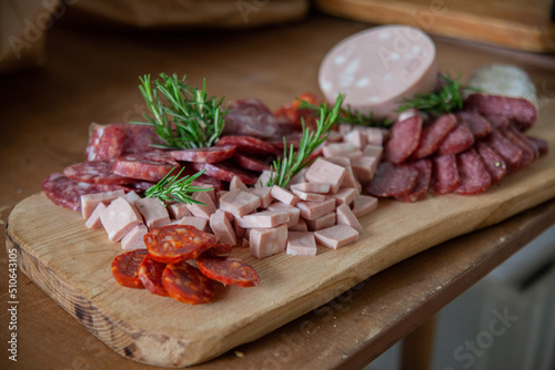 Fototapeta Naklejka Na Ścianę i Meble -  Cutting board with variety of typical Italian cold cuts and meats placed on the preparation table during a catering event