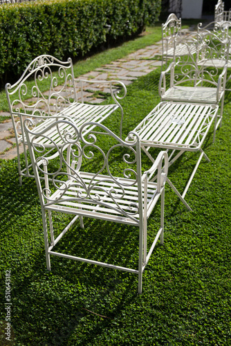 Garden with elegant and antique white tables and chairs during a wedding ceremony event