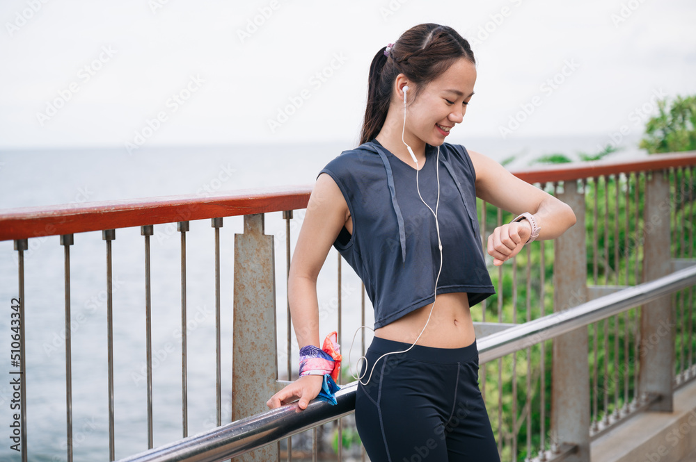 Portrait beautiful Asia woman checking smart watch after exercise jogging	