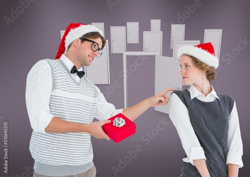 Caucasian man giving christmas gift to his wife with doors icon and copy space on purple background