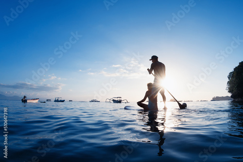 Photography Young happy couple have fun on stand up paddleboard