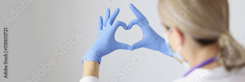 Medical worker form heart with hands wearing protective gloves
