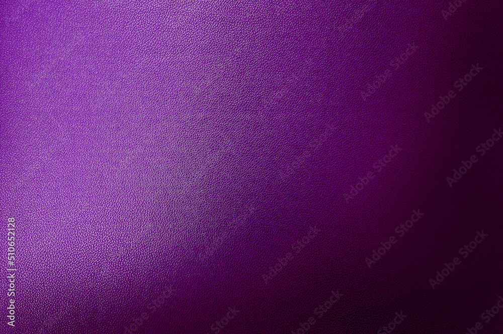 luxury dark purple leather texture background showing grain and a shaft of light across. gradient violet artificial leatherette texture use as background, close up view, with blank space for design.