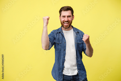 Happy joyful man doing winner gesture clenching fists 