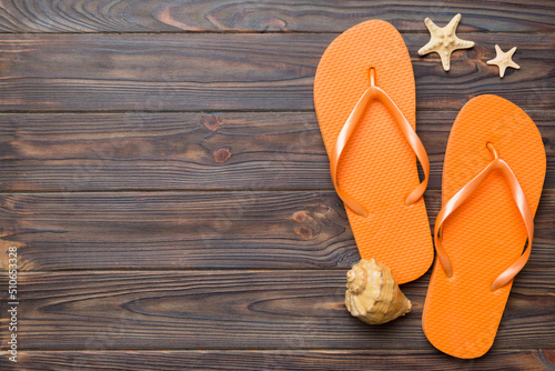 Flat lay composition with flip flops and seashell on colored background. Space for text top view