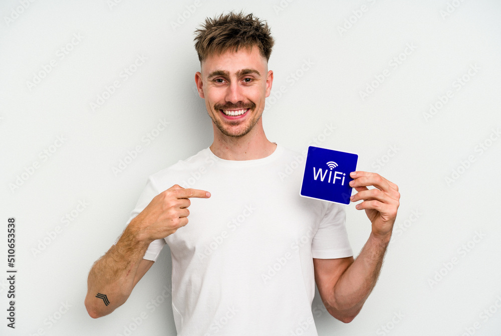 Young caucasian man holding wifi placard isolated on white background person pointing by hand to a shirt copy space, proud and confident Young caucasian man holding wifi placard isolated on white background person pointing by hand to a shirt copy space, proud and confident