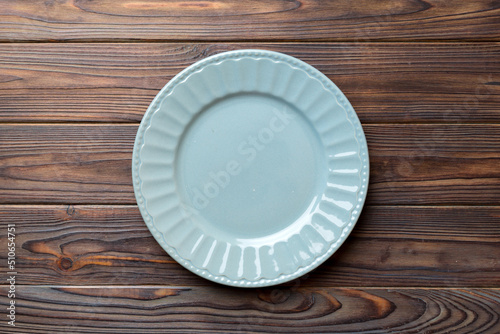 Top view of empty grey plate on wooden background. Empty space for your design