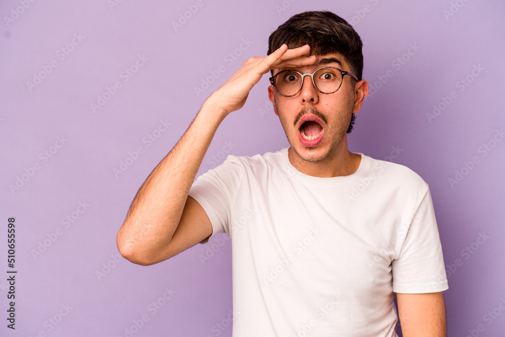 Young caucasian man isolated on purple background shouts loud, keeps eyes opened and hands tense. Young caucasian man isolated on purple background shouts loud, keeps eyes opened and hands tense.