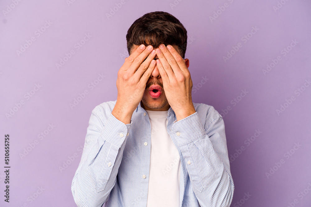 Young caucasian man isolated on purple background afraid covering eyes with hands. Young caucasian man isolated on purple background afraid covering eyes with hands.