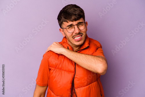 Young caucasian man isolated on purple background having a shoulder pain.