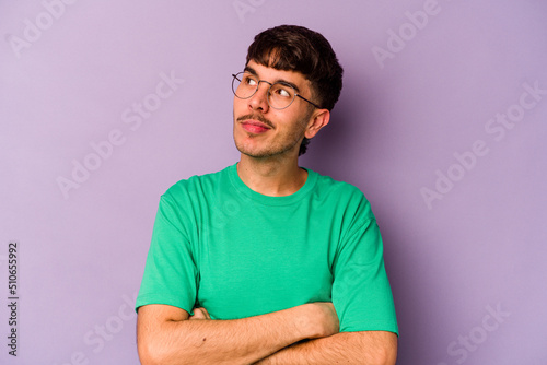 Young caucasian man isolated on purple background dreaming of achieving goals and purposes