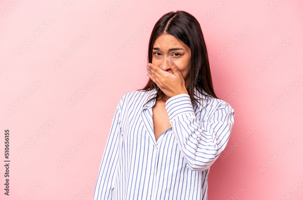 Young hispanic woman isolated on pink background covering mouth with hands looking worried. Young hispanic woman isolated on pink background covering mouth with hands looking worried.