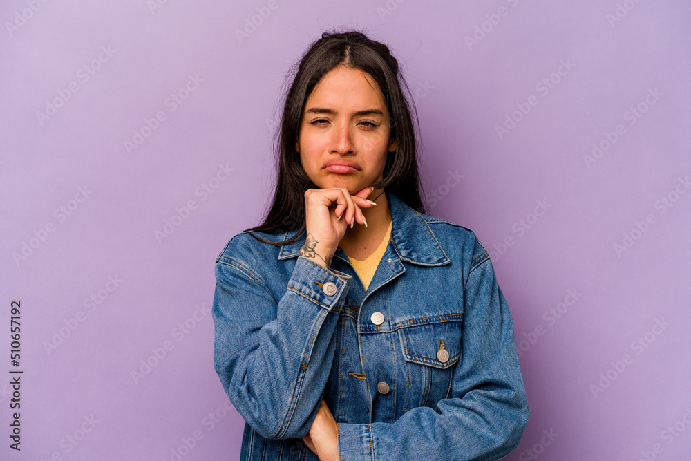 Young hispanic woman isolated on purple background thinking and looking up, being reflective, contemplating, having a fantasy. Young hispanic woman isolated on purple background thinking and looking up, being reflective, contemplating, having a fantasy.