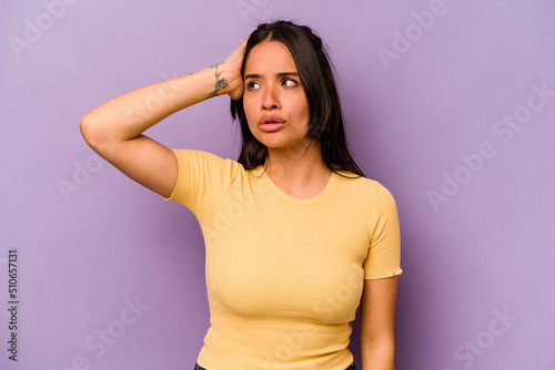 Young hispanic woman isolated on purple background being shocked, she has remembered important meeting.