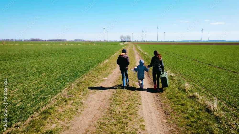 Mother and her children running by country road. Refugees from Ukraine during evacuation. Concept of peaceful and carefree life without armed conflicts Mother and her children running by country road. Refugees from Ukraine during evacuation. Concept of peaceful and carefree life without armed conflicts