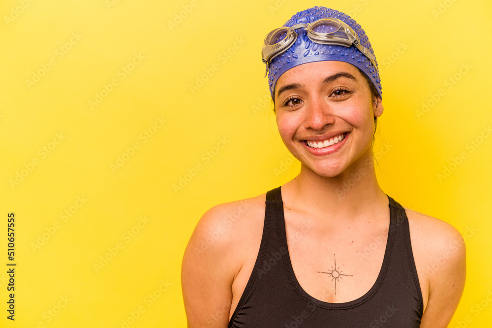 Young swimmer hispanic woman isolated on yellow background Young swimmer hispanic woman isolated on yellow background
