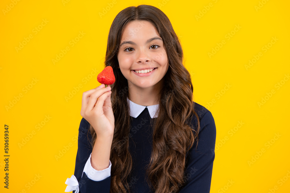 Appetizing strawberry. Portrait of cute teen girl eating strawberries isoalted on yellow background. Appetizing strawberry. Portrait of cute teen girl eating strawberries isoalted on yellow background.