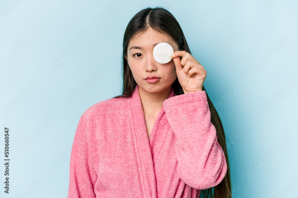 Young asian woman holding a facial disk isolated on pink background Young asian woman holding a facial disk isolated on pink background