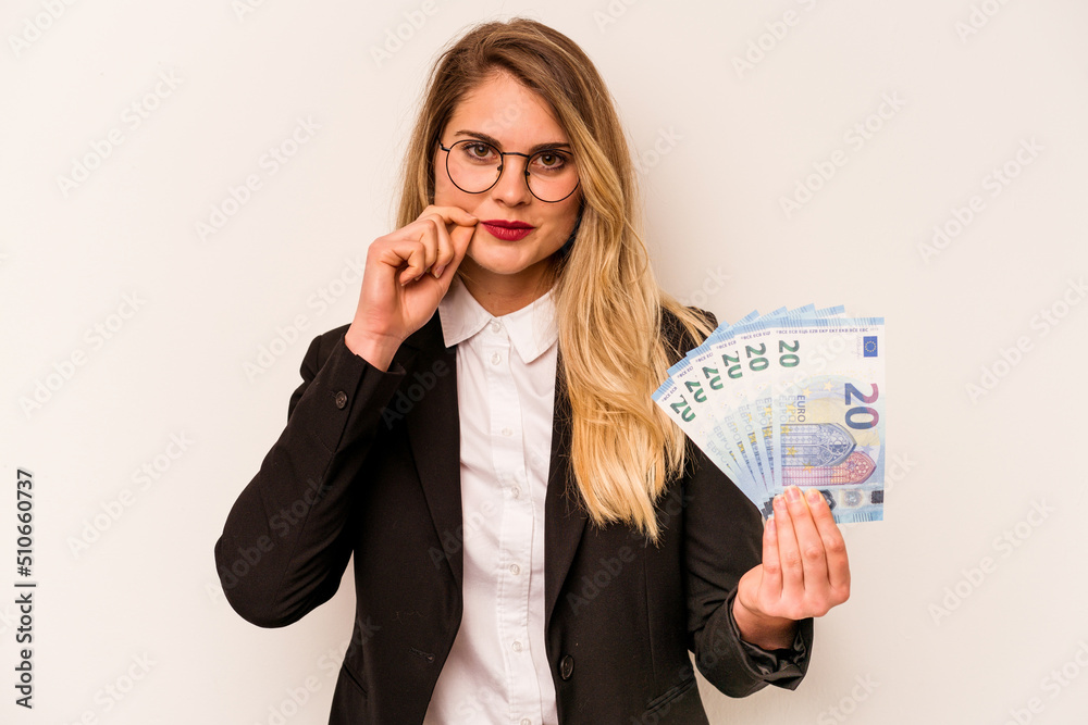 Young business caucasian woman holding a banknotes isolated on white background with fingers on lips keeping a secret. Young business caucasian woman holding a banknotes isolated on white background with fingers on lips keeping a secret.
