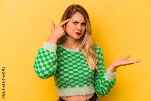 Young caucasian woman isolated on yellow background showing a disappointment gesture with forefinger.