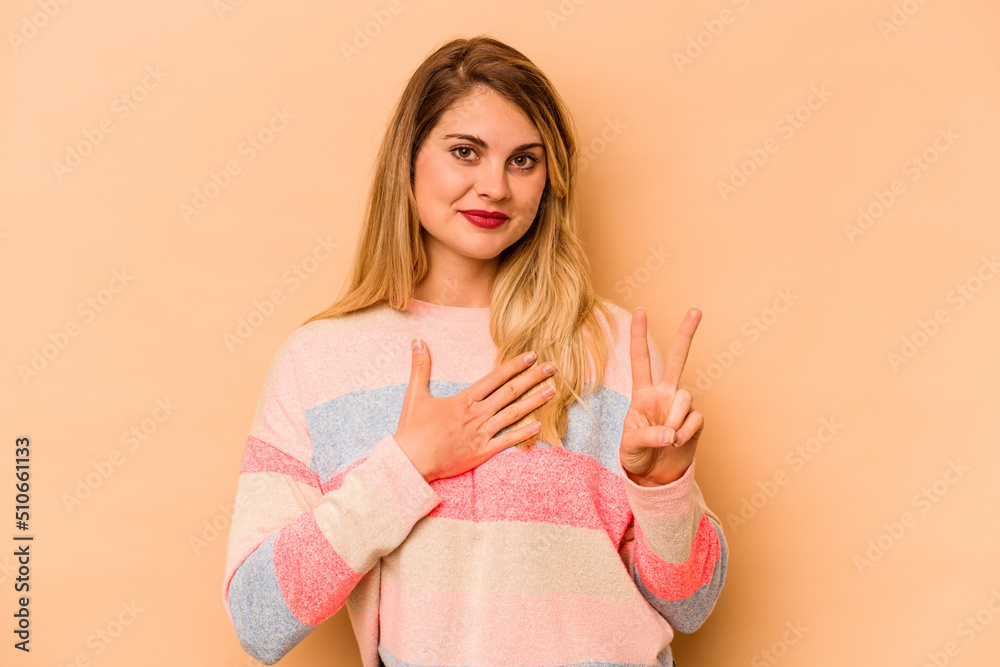 Young caucasian woman isolated on beige background taking an oath, putting hand on chest. Young caucasian woman isolated on beige background taking an oath, putting hand on chest.