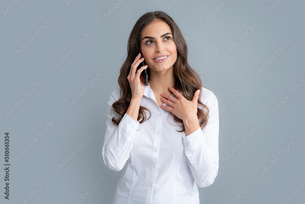 Smiling woman talking on mobile phone, isolated over gray background. Girl with mobile cell phone. Smiling woman talking on mobile phone, isolated over gray background. Girl with mobile cell phone.