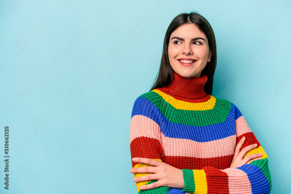 Fototapeta premium Young caucasian woman isolated on blue background smiling confident with crossed arms.