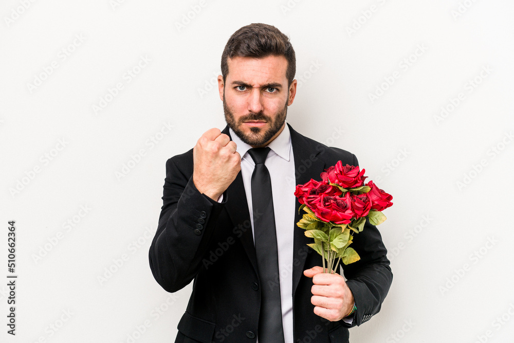 Young caucasian man holding a bouquet of flowers isolated on white background showing fist to camera, aggressive facial expression. Young caucasian man holding a bouquet of flowers isolated on white background showing fist to camera, aggressive facial expression.
