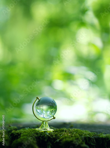 glass earth globe on abstract blurred natural green background. Concept of ecology, save nature, earth protection, eco friendly, Environment conservation. copy space photo
