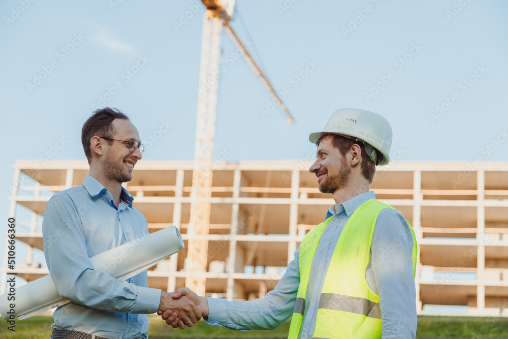 Architect and consumer handshaking on construction site. building, teamwork, partnership concept Architect and consumer handshaking on construction site. building, teamwork, partnership concept
