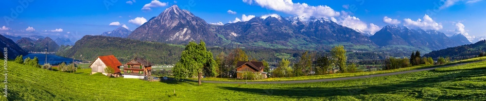 Switzerland nature scenery - typical traditional village with green meadows and wooden houses near Lucerne town and lake with stunning view for Pilatus mountain