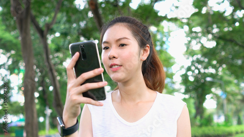 Lifestyle portrait woman outdoors city and using mobile gadget, girl banker dressed in casual style looking social media and typing text message on smartphone device.