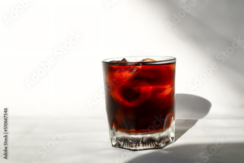 Close up of Cola with ice cubes in the glass on white background.