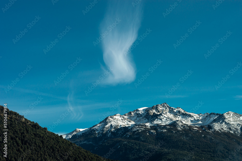 Snowy mountain summit with strange cloud formation