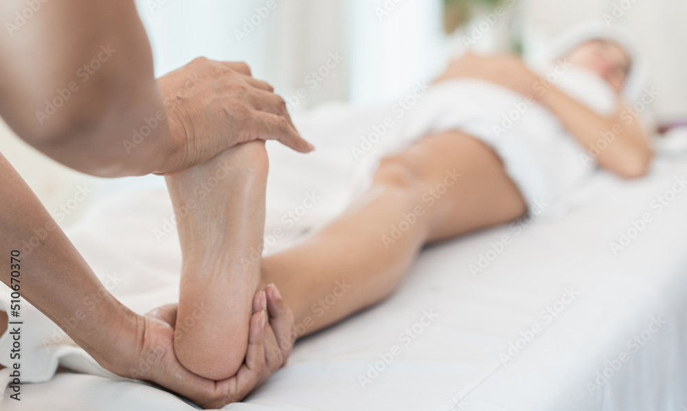 Beautiful young woman receiving massage in spa salon. Masseuse uses herbs to massage the back and legs. Beautiful young woman receiving massage in spa salon. Masseuse uses herbs to massage the back and legs.