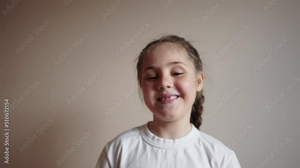 little girl smiling holding a glass of water. the child looks close-up into the video camera. happy family childhood dream concept. portrait girl daughter lifestyle smiling funny indoors little girl smiling holding a glass of water. the child looks close-up into the video camera. happy family childhood dream concept. portrait girl daughter lifestyle smiling funny indoors