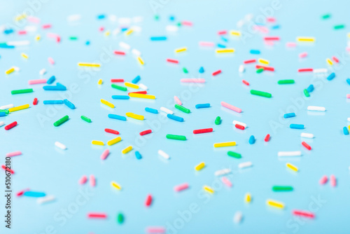 Photo colorful sprinkles over blue background, decoration