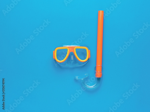 A set of swimming mask and snorkel on a blue background. Minimal concept of summer recreation and scuba diving.