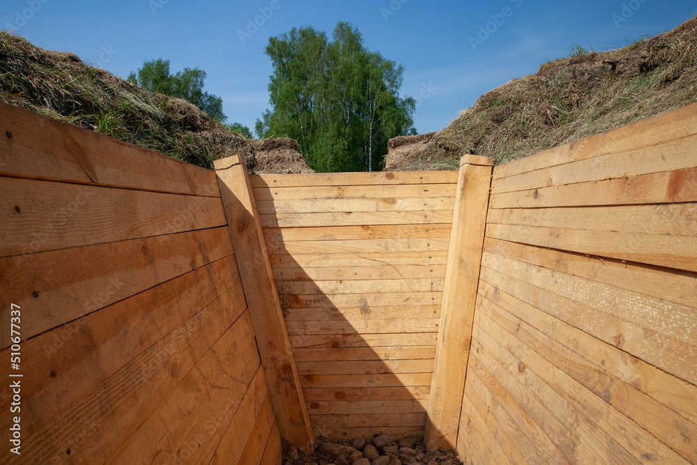 Fototapeta premium dug in the ground and reinforced with improved boards trench