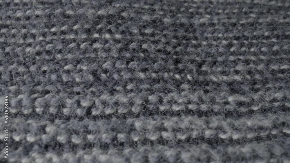Knitted gray wool fabric in macro. Structure of warm garment, sweaters, cozy plaid, bedspreads, scarf. Knitted soft material made of wool. Background from knitted textile. Extreme close up of fluffy Knitted gray wool fabric in macro. Structure of warm garment, sweaters, cozy plaid, bedspreads, scarf. Knitted soft material made of wool. Background from knitted textile. Extreme close up of fluffy
