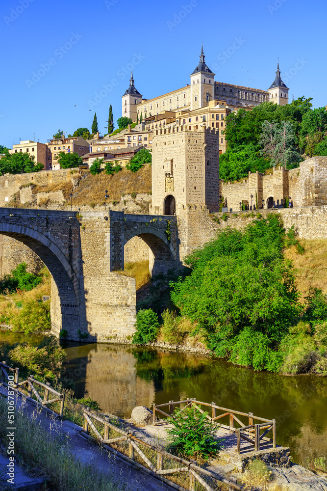 Old stone buildings of the medieval city of Toledo next to the Tagus River.