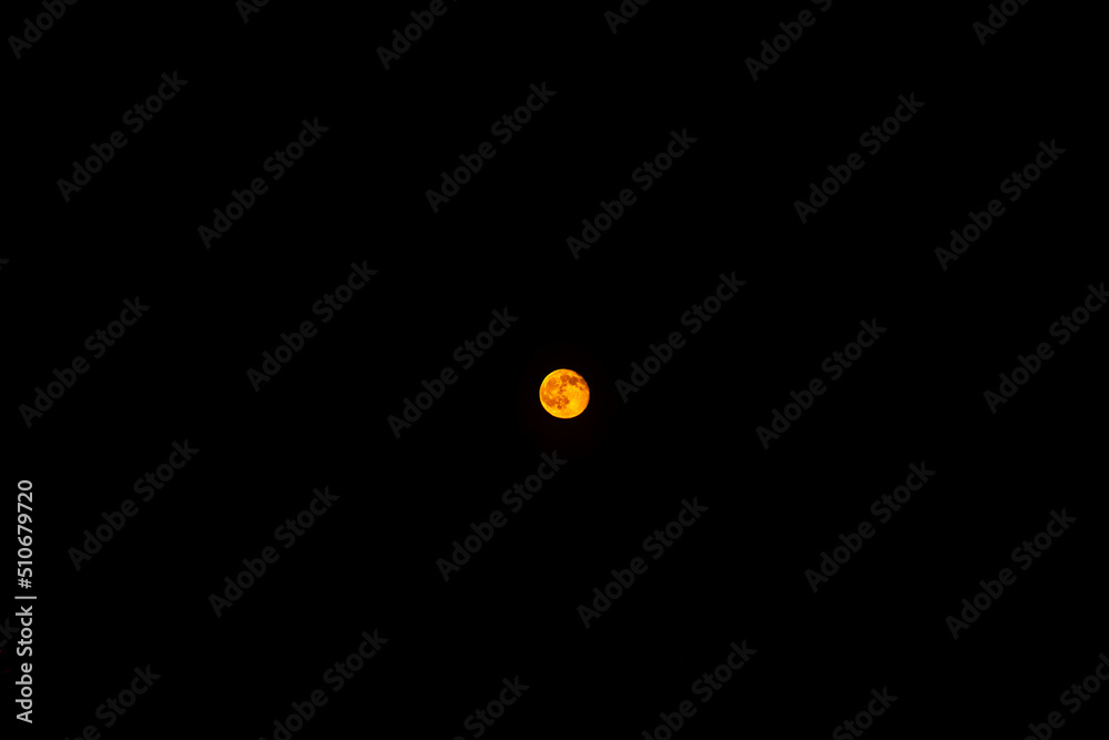 orange moon in a black starless sky, full moon in the sky at night orange moon in a black starless sky, full moon in the sky at night