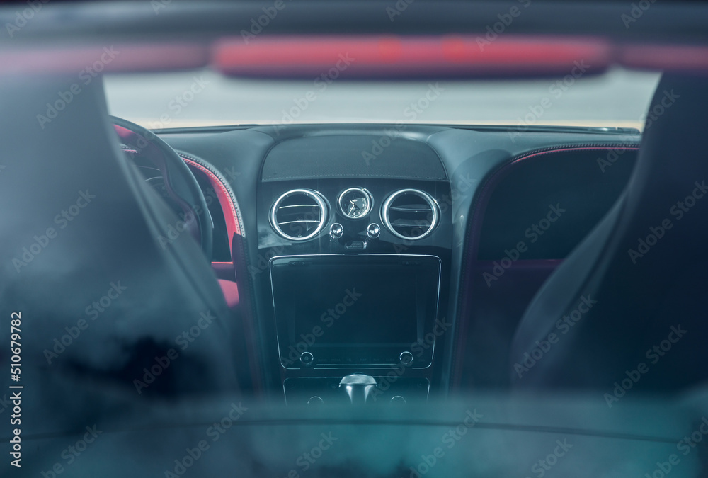 Digital screen on a cars dashboard viewed through the rear window