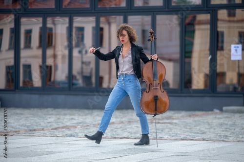 A female musician with a cello on the street photo